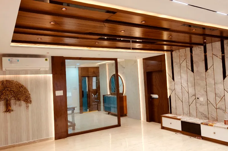 Timber ceiling beams over a marble feature wall.